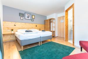 1 dormitorio con cama y alfombra verde en Sonnberg Lodge, en Maria Alm am Steinernen Meer