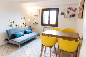 a living room with a blue couch and yellow chairs at Lion Rooftop Apartments Venice NOVITA' in Venice
