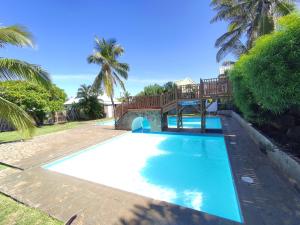 a swimming pool with a deck on top of it at T2 à 300m de la plage in La Saline Les hauts 