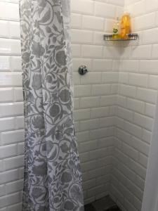a shower with a black and white shower curtain at Just a Bed in Stellenbosch