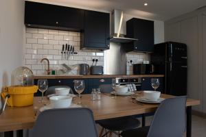 a kitchen with a wooden table with chairs and wine glasses at Unique Barn conversion in Saddleworth in Oldham