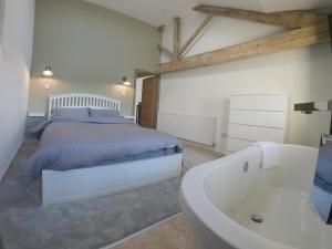 um quarto com uma cama e uma banheira em Unique Barn conversion in Saddleworth em Oldham