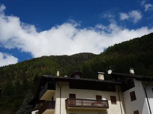 a building with a balcony on the side of a mountain at Casa Al Noce Mastellina Apt. Solandra in Commezzadura