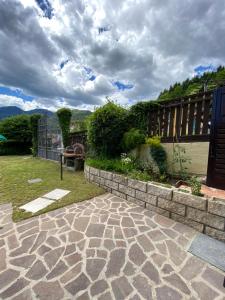 a backyard with a stone walkway and a fence at Casa Nina in Mezzolago
