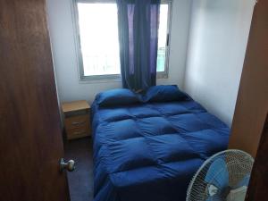 a small bedroom with a blue sleeping bag in it at La Isla in Punta Del Diablo