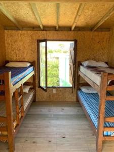 a room with two bunk beds and a window at La Isla in Punta Del Diablo