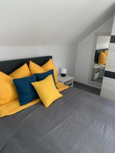 una camera da letto con un letto con cuscini gialli e blu di Miseta Apartman a Fonyód