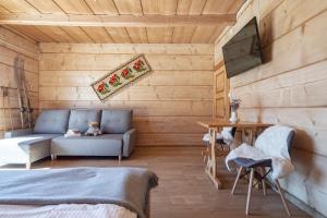 een slaapkamer met houten wanden en een bank en een tafel bij Dom Tatrzański Ewa in Kościelisko