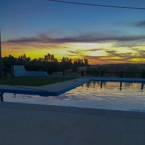 an empty swimming pool with a sunset in the background at Turismo Rural Pão e Água in Mértola
