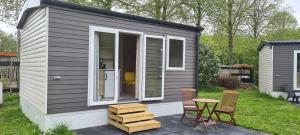 a tiny house with a table and chairs at Mini-chalet - Vakantiepark 't Urkerbos in Urk