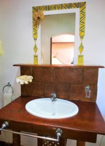 a bathroom with a sink and a mirror at Hotel Les Boucaniers in Ambatoloaka