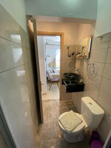 a small bathroom with a toilet and a sink at Anastasia Studios, Apartments & Suites in Archangelos +245 photos