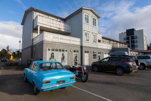 una macchina blu parcheggiata in un parcheggio di fronte a un edificio di Central Apartment with Two bedrooms and Balcony- Strandgata 9 ad Akureyri