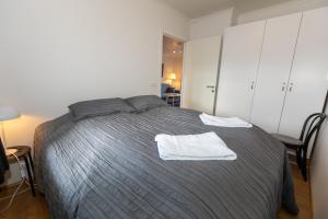 una camera da letto con un letto e asciugamani bianchi di Central Apartment with Two bedrooms and Balcony- Strandgata 9 ad Akureyri