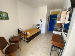 a bedroom with a bed and a blue door at Anastasia Studios, Apartments & Suites in Archangelos