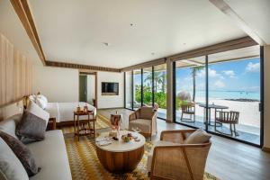 a living room filled with furniture and a balcony at Kuda Villingili Resort Maldives in North Male Atoll