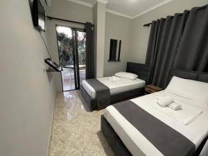 a hotel room with two beds and a television at Villa Balbi 34 in Sarandë