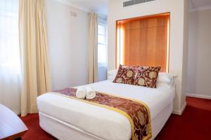 Una habitación de hotel con una cama con dos toallas. en Linaker Art Deco Motel, en Beechworth