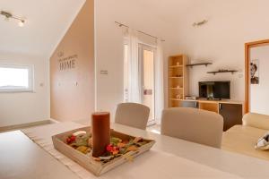 a white living room with a table and chairs at Apartmani Tanja in Martinšćica