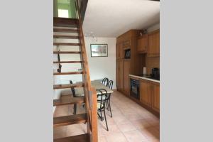 a kitchen with a spiral staircase and a table with chairs at T2 Bis, calme, plein centre de Luchon, avec balcon et garage in Luchon