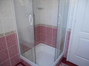una doccia con una porta in vetro in un bagno di Miseta Apartman a Fonyód Altre 10 foto