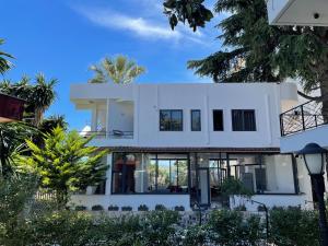 a white house with palm trees in front of it at Villa Balbi 34 in Sarandë