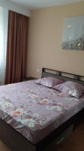 a bedroom with a bed with a floral bedspread at CASA LIVIA in Slatina