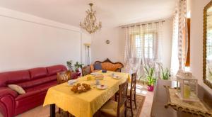 a living room with a table and a red couch at Bed&Breakfast Il Frantoio in Misano Adriatico