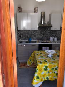 uma cozinha com uma mesa com uma toalha de mesa florida em Casa Vacanza I Due Mori em Avola