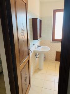La salle de bains est pourvue d'un lavabo, de toilettes et d'une porte. dans l'établissement Agriturismo da Lino AGRIPIZZA, à Samughèo