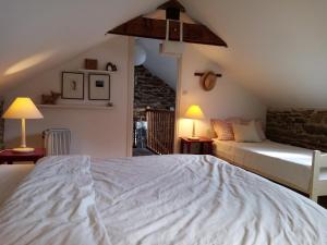 sypialnia z dużym białym łóżkiem i 2 lampami w obiekcie Le Grand Guillaume w mieście Saint-Sornin-Lavolps