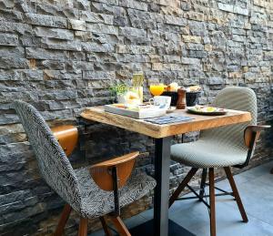 een houten tafel met stoelen en eten erop bij Hotel Het Menneke in Hasselt