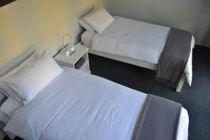 白河的住宿－SleepOver KMIA，酒店客房设有两张床和床头柜。