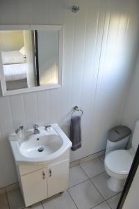 a bathroom with a sink and a toilet and a mirror at SleepOver KMIA in White River