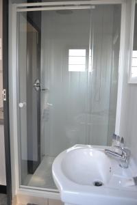 a bathroom with a shower and a white sink at SleepOver KMIA in White River