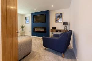 a living room with a blue chair and a fireplace at Fletchers Rest in Whitby