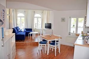 奥斯赛拜-塞林Fewo 20 mit Strandkorb und Balkon的客厅里有一张蓝色的沙发和一张桌子