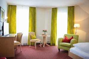 a hotel room with a bed and a table and chairs at Castell Hotel & Restaurant in Leinsweiler