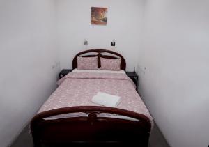 a small bedroom with a bed with pink sheets at Welcome Guest House in Lisbon