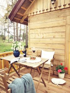 een houten patio met een tafel en stoelen op een terras bij Pape holiday home in Pape