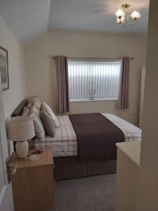 a small bedroom with a bed and a window at Oaktree Lodge in Doncaster