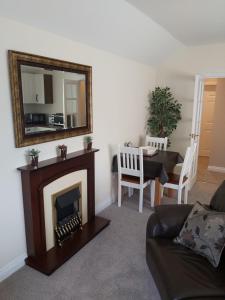 a living room with a fireplace and a mirror at Oaktree Lodge in Doncaster