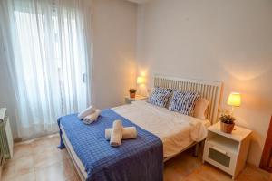 a bedroom with a bed with two towels on it at Gloria Apartment by Hello Homes Sitges in Sitges