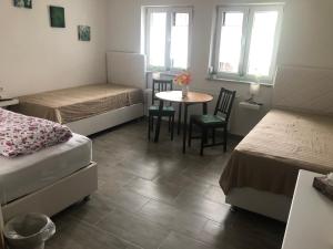 a room with two beds and a table and chairs at Gästehaus Glock in Marbach am Neckar