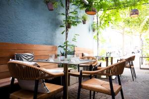 a table and chairs in a restaurant with trees at Livingloft Apartments in Bad Saulgau