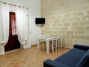 un soggiorno con tavolo e sedie bianchi di Case Vacanze Mariposa a Favignana