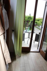 a sliding glass door leading to a balcony with a table at Agriturismo Al-Bor in Lazise