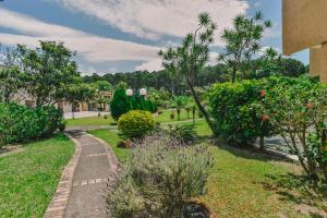 um caminho através de um parque com árvores e arbustos em Villa Oliva Residence em Florianópolis