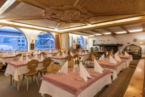 un comedor con mesas, sillas y ventanas en Ferienwohnungen Seraina, en Sils-Maria