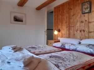 two beds in a room with wooden walls at Haus Pinter in Assling